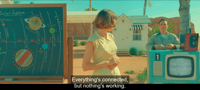 a still from Asteroid City (film by Wes Anderson) with the text "Everything's connected, but nothing's working."